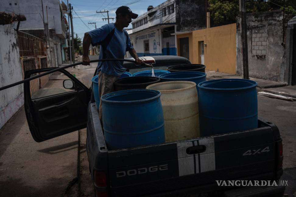 $!Un hombre llena bidones con agua debido a la escasez causada por las altas temperaturas y la sequía en Veracruz, México.