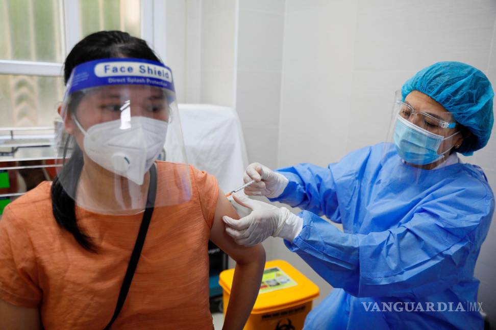 $!Una mujer embarazada se vacuna contra la covid-19 con una dosis de Pfizer, en Hanoi, Vietnam. EFE/Luong Thai Linh