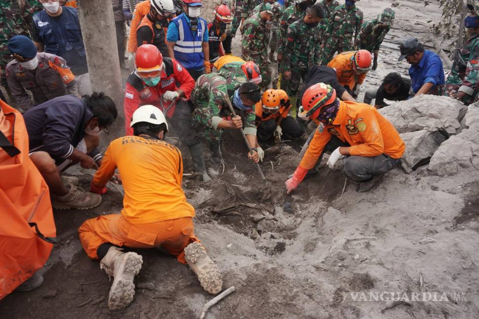 $!Equipos de rescate excavan en busca del cuerpo de una víctima enterrada por la ceniza volcánica en un área afectada por la erupción del monte Semeru . EFE/EPA/AMMAR