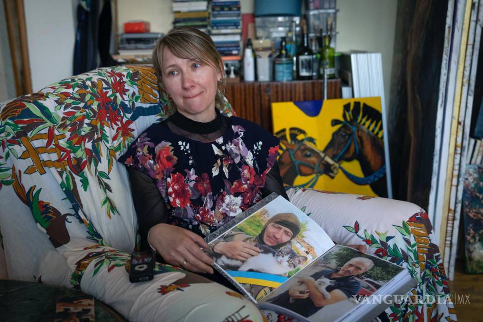 $!Yuliia Movchan, la esposa de un militar ucraniano que murió en batalla con las tropas rusas, muestra fotos de su esposo en un estudio de arte en Kiev, Ucrania.
