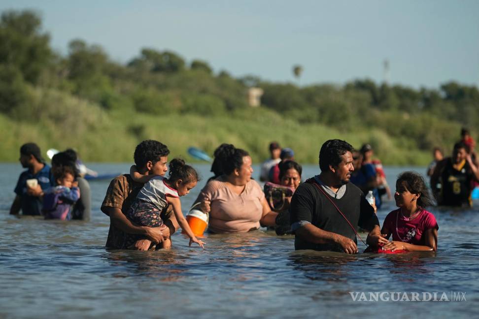 $!Migrantes caminan alrededor de alambre de púas a lo largo de las orillas del Río Grande después de cruzar de México a EU en Eagle Pass, Texas.