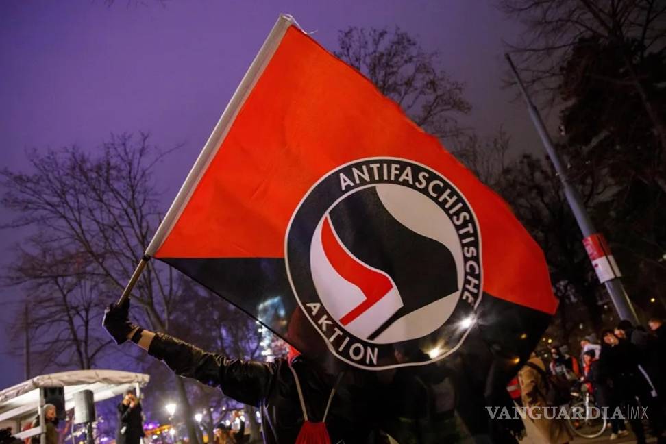 $!Una persona con una bandera del grupo “Informal Anarchist Federation”, “Federación Anarquista Internacional” en español.
