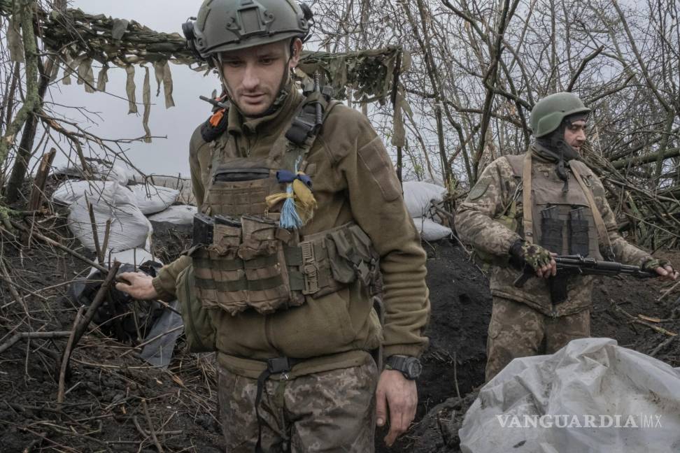 $!Los soldados ucranianos se mueven alrededor de la trinchera mientras observan el horizonte donde están estacionadas las tropas rusas en Bakhmut, Ucrania.