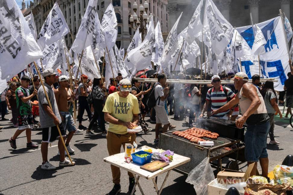 $!Un hombre compra un almuerzo mientras participa en una manifestación de trabajadores estatales contra las medidas de austeridad de Javier Milei.