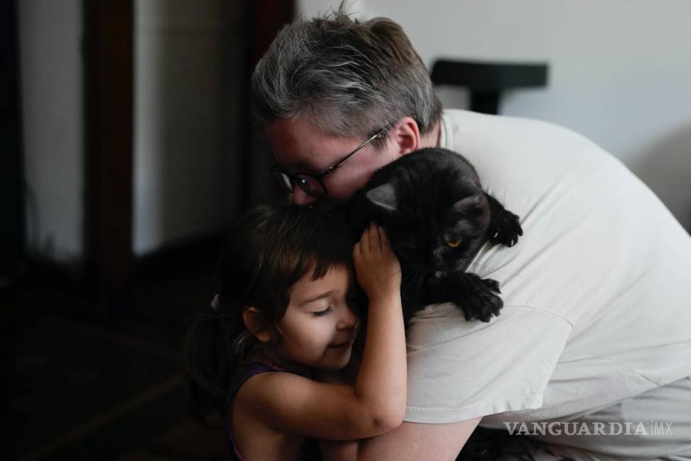 $!Anna Domini y su hija Agata, de 3 años, abrazan a su gato Faust en su casa de Buenos Aires, Argentina.