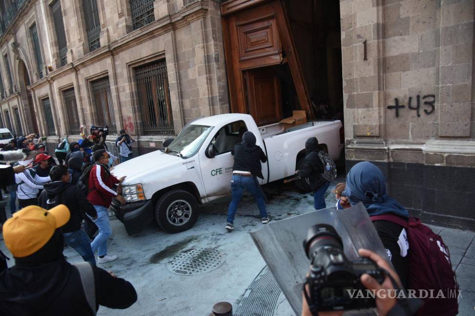 $!Estudiantes de la Escuela Normal Rural Raúl Isidro Burgos utilizaron una camioneta de la CFE como ariete para derribar la.puerta de Palacio Nacional.