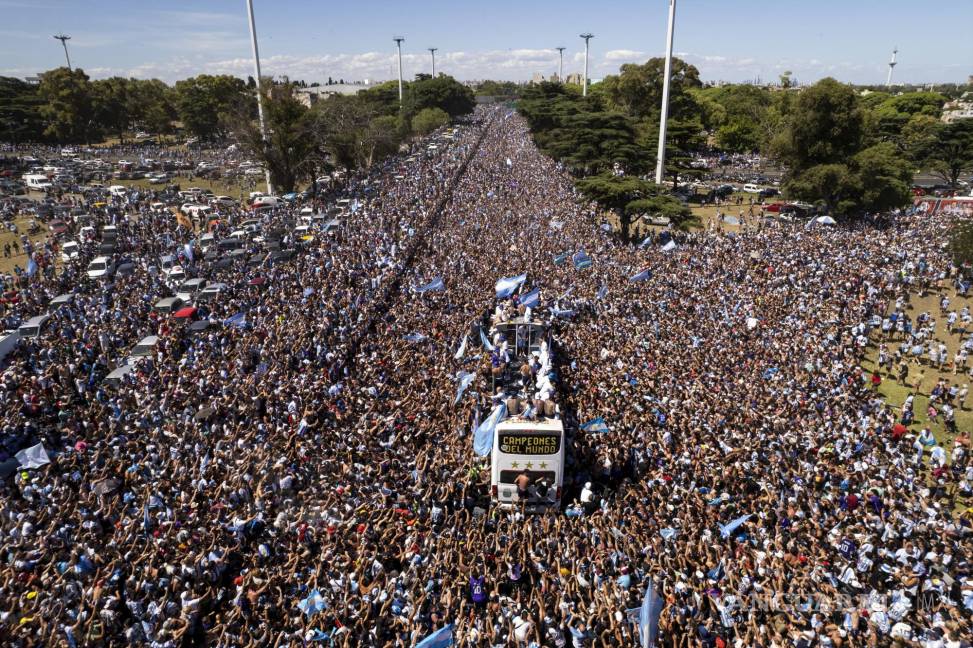 $!Un mar de gente rodea el autobús que conduce a la selección argentina en Buenos Aires, el martes 20 de diciembre de 2022, tras su coronación en Qatar 2022.