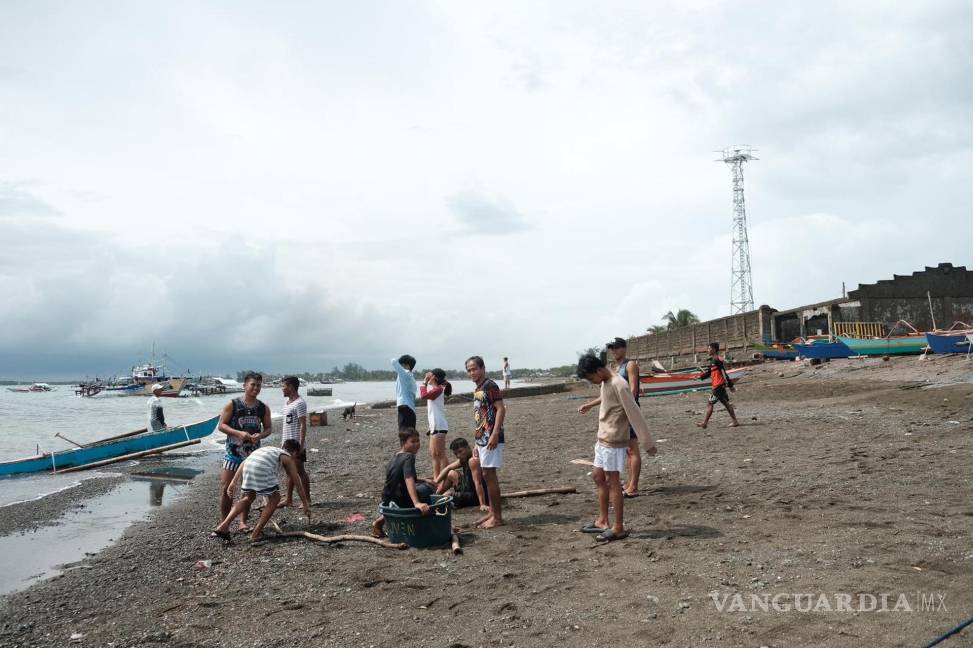 $!Niños y familias regresan a sus hogares un día después de que el supertifón Noru azotara su comunidad pesquera en el pueblo costero de Dinahican, Filipinas.