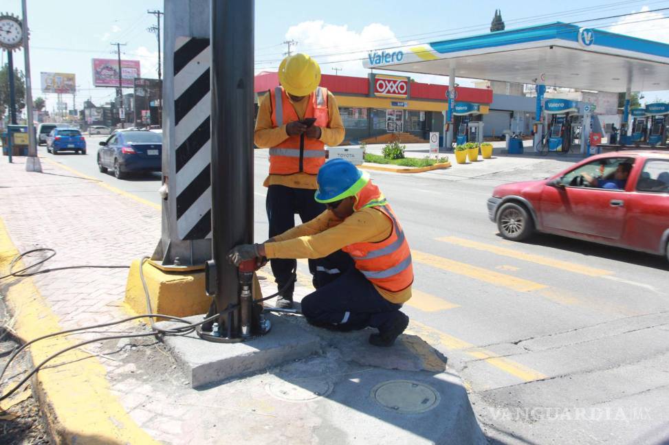 $!Trabajadores del Municipio colocan la postería donde serán instalados los semáforos inteligentes.