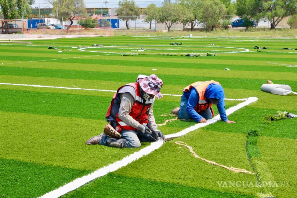 $!Casi queda concluida la colocación de césped artificial en una de las canchas de futbol.