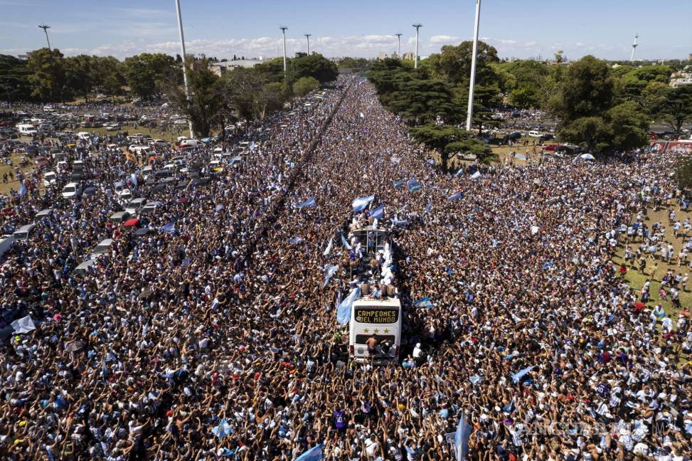 $!El equipo de fútbol argentino que ganó el título de la Copa del Mundo viaja en un autobús abierto durante su desfile de bienvenida en Buenos Aires, Argentina.