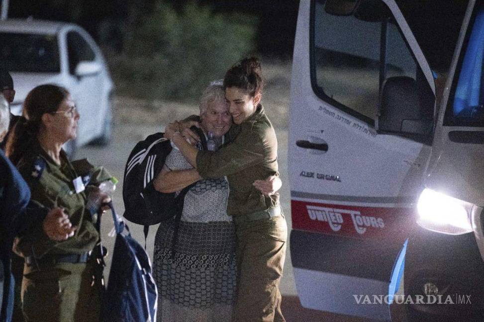 $!Margalit Mozes, una rehén israelí liberada, camina con un soldado israelí poco después de su llegada a Israel el viernes 24 de noviembre de 2023.