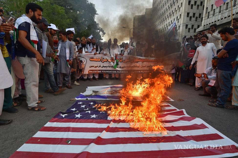 $!Los manifestantes queman una bandera estadounidense y otra israelí durante una protesta contra Israel en solidaridad con el pueblo palestino en Karachi, Pakistán.