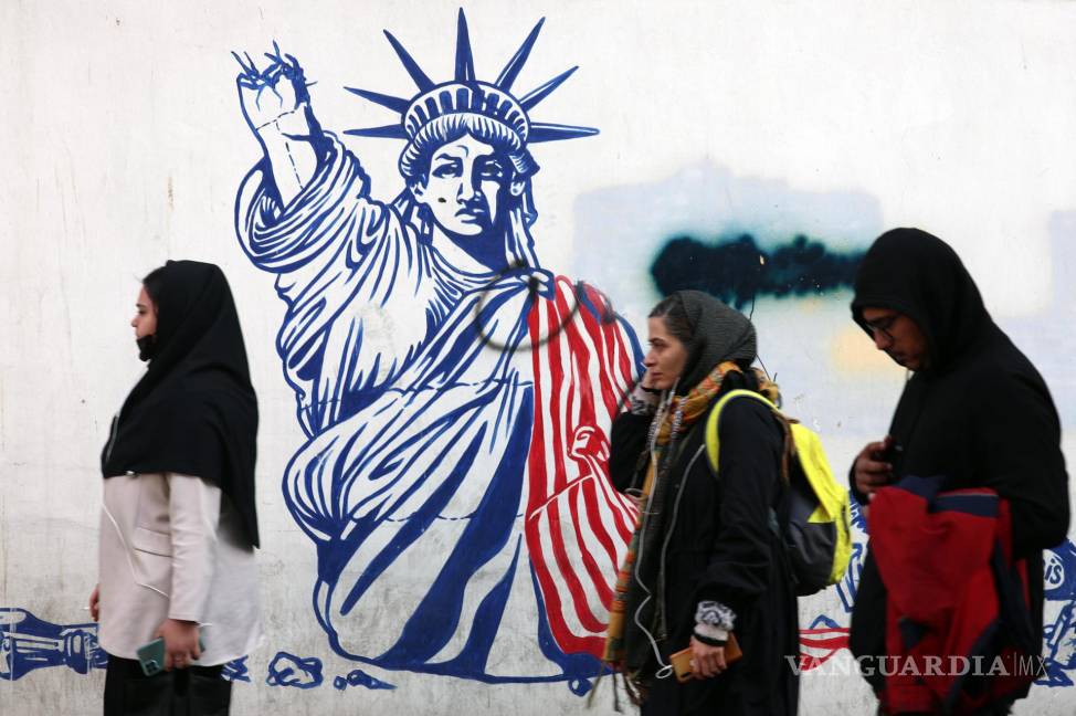 $!Tres mujeres pasan ante un grafiti antiestadounidense junto a la antigua embajada de Estados Unidos en Teherán.