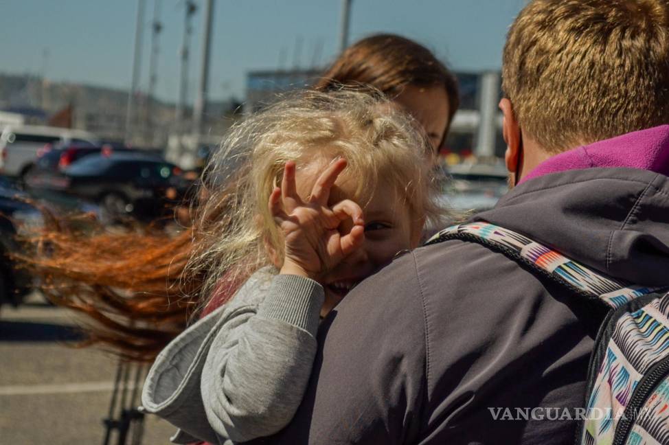 $!Una niña parte del grupo de familias de Rusia y Ucrania que esperan para solicitar Asilo Poltíco reacciona mientras espera en la garita de San Ysidro, para intentan ingresar a Estados Unidos hoy, en la ciudad de Tijuana.
