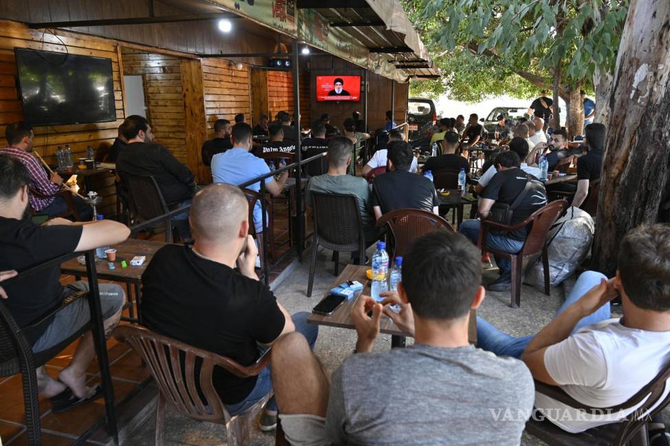 $!La gente observa al Secretario General de Hezbolá, Hassan Nasrallah, que da un discurso televisado en una cafetería en el suburbio sur de Beirut, Líbano.