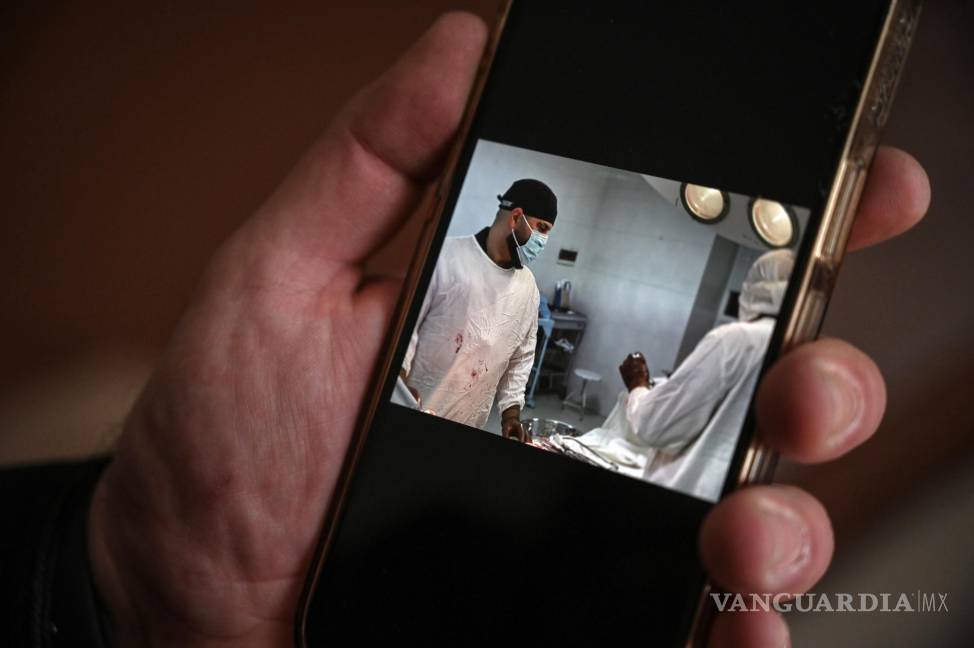 $!El Dr. Samer al-Sheikh muestra fotos en su teléfono de su trabajo quirúrgico en Ucrania, en su casa de Earl’s Court, Londres.