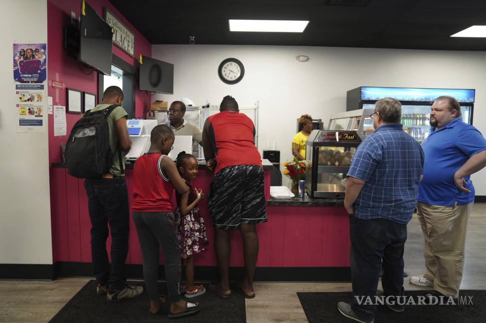 $!Romane Pierre, del restaurante criollo Rose Goute en Springfield, Ohio, ayuda a una fila de clientes.