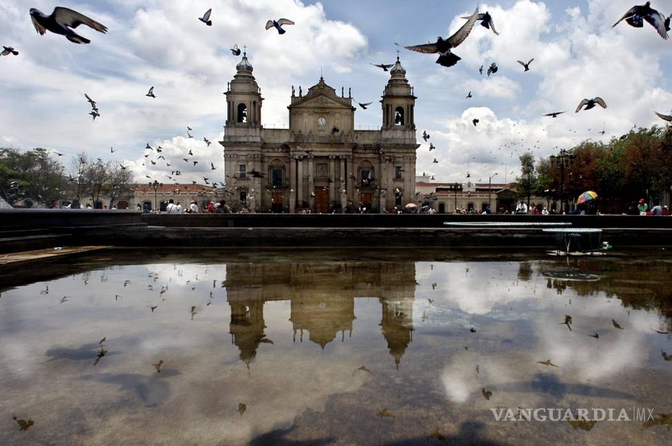 $!La catedral metropolitana de Guatemala se refleja en el agua junto a cientos de palomas. EFE/Ulises Rodríguez