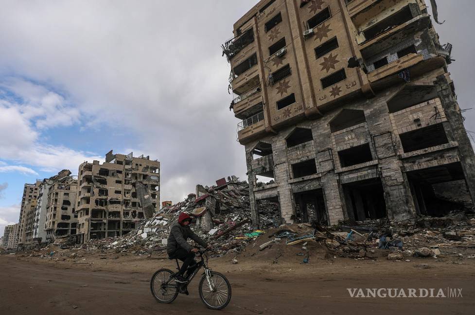 $!Un palestino pasa en bicicleta frente a edificios destruidos en la ciudad de Gaza en medio de un alto el fuego entre Israel y Hamás, Franja de Gaza.