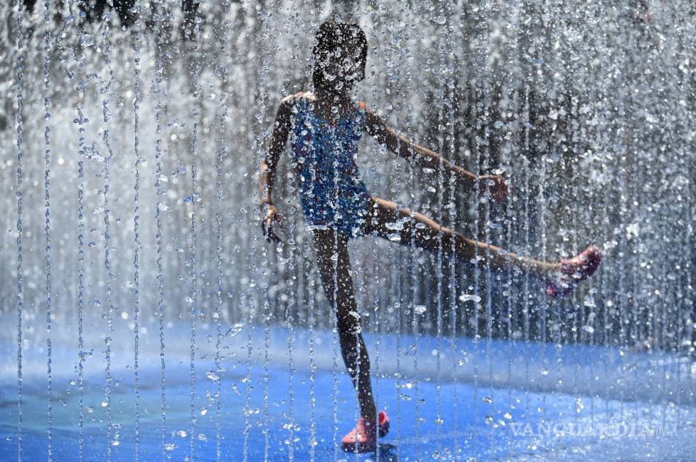 $!Una niña juega en una fuente en Londres, Gran Bretaña. Por primera vez el Reino Unido superó este hoy por primera los 40 grados centígrados.