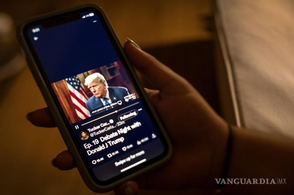 $!Un espectador mira la entrevista de Donald Trump por parte de Tucker Carlson en la plataforma ‘X’ de su teléfono en Miami, Florida.