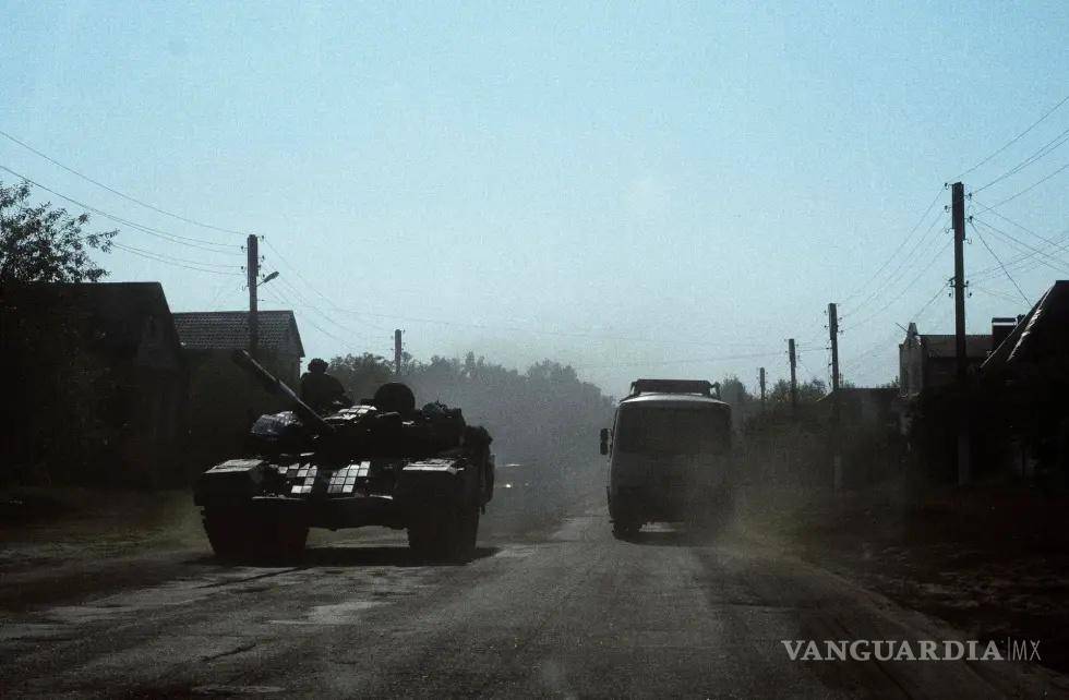 $!Un autobús civil circulaba el pasado mes de agosto junto a un tanque ucraniano a 9 kilómetros de la frontera con Rusia, en la región ucraniana de Sumi.