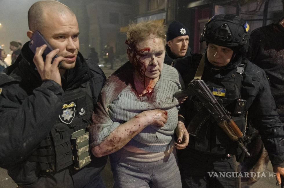 $!Los ataques rusos a Ucrania continuaban este sábado y un hombre es ayudado por policías en la ciudad de Kharkiv.