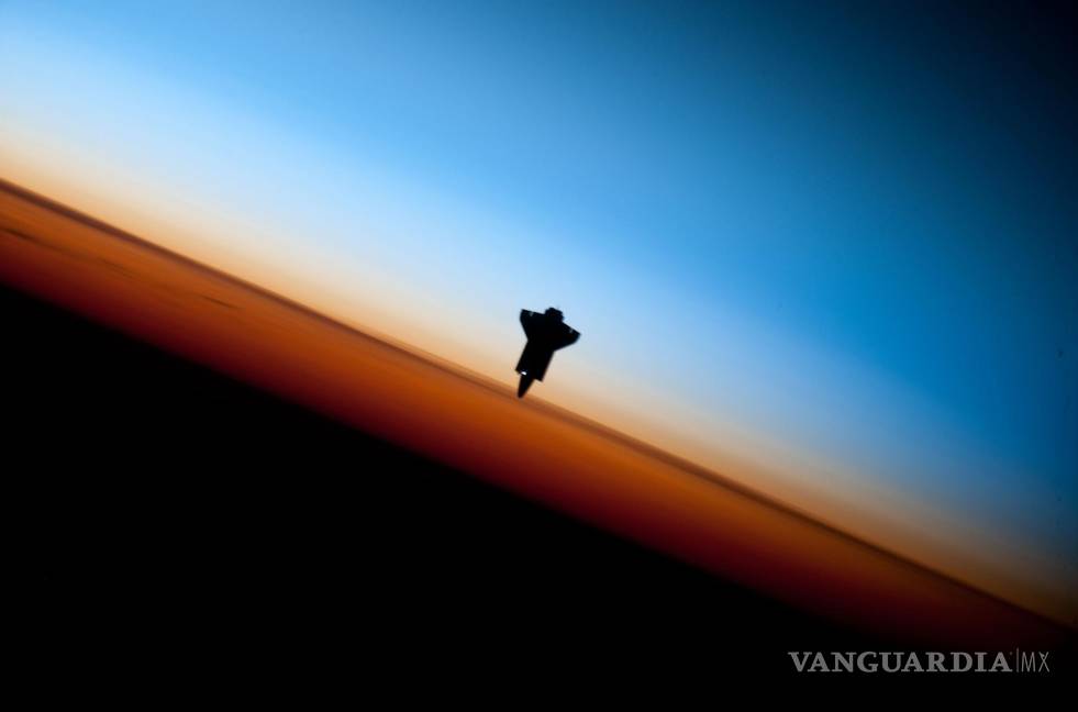 $!El transbordador espacial Endeavour en camino a acoplarse a la EEI en 2010, con la capa de la troposfera de la Tierra, en naranja, claramente visible.