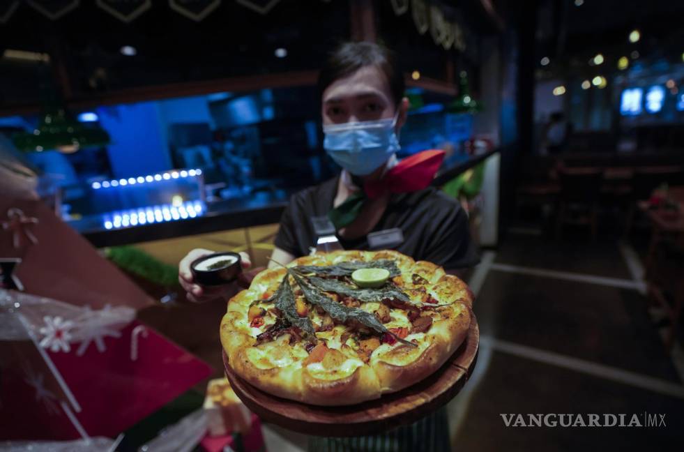$!Un miembro del personal muestra una pizza cubierta con una hoja de cannabis en un restaurante de Bangkok, Tailandia. AP/Sakchai Lalit