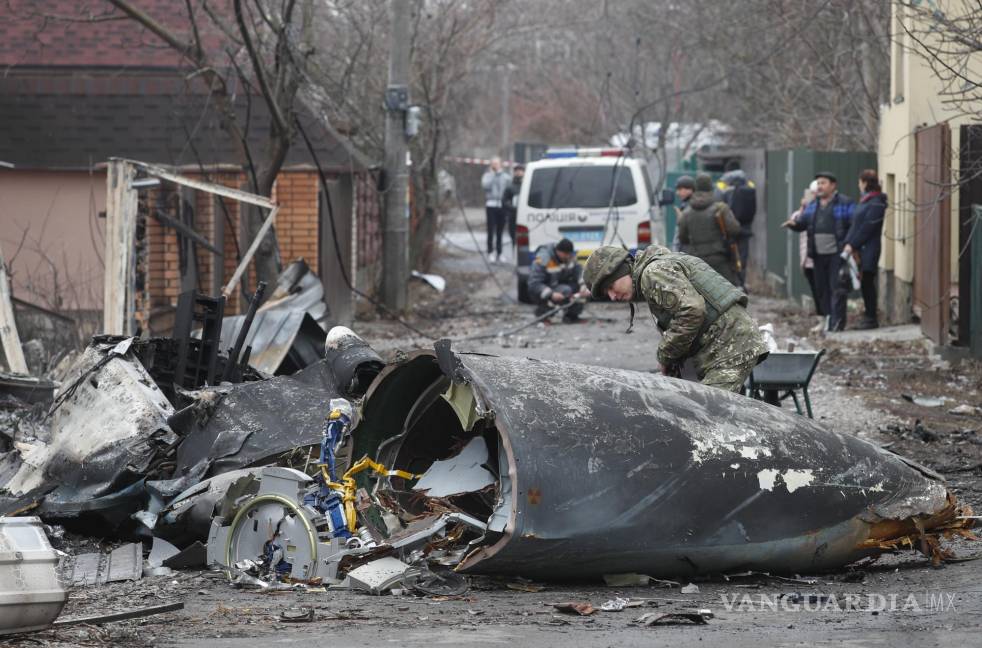 $!Un soldado observa los restos de un avión militar derribado durante la noche del 25 de febrero de 2022 en Kiev, Ucrania. EFE/Sergey Dolzhenko