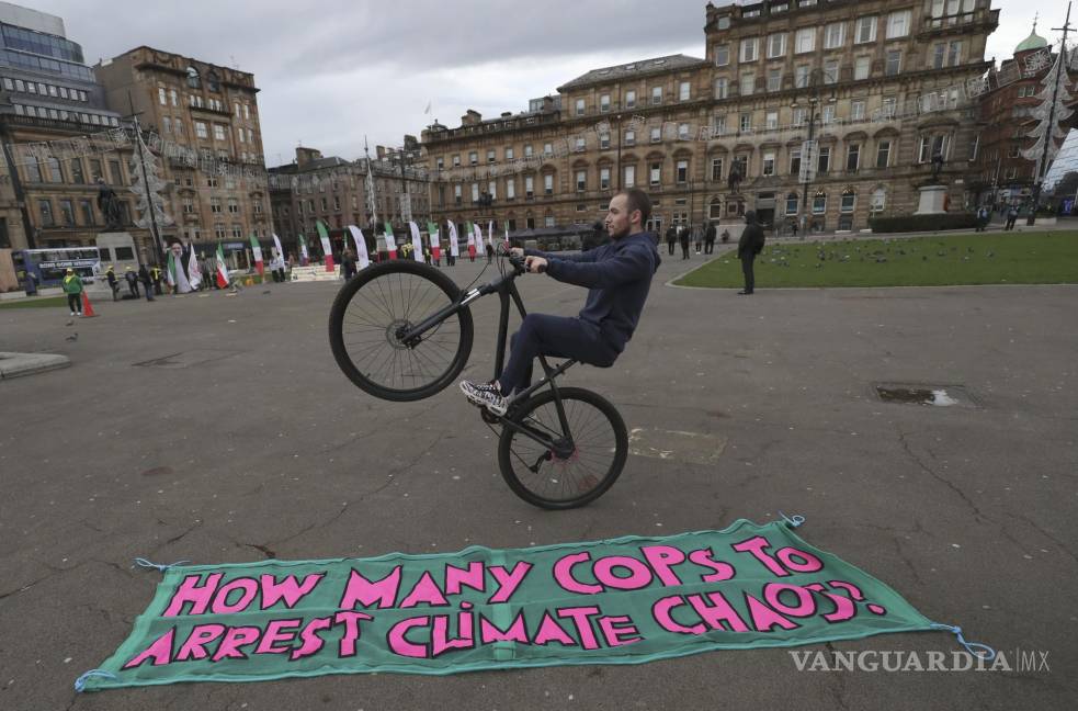 $!Un hombre en su bicicleta delante de su pancarta protestando al margen de la COP26 Cumbre del Clima de la ONU en Glasgow, Escocia. AP/Scott Heppell