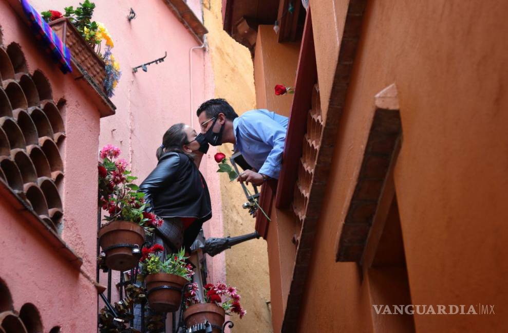 $!Dos jovenes se besan con un cubrebocas en el famoso y tradicional callejon del beso en Guanajuato.