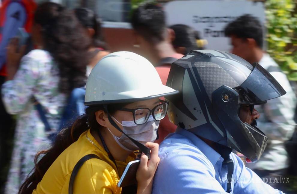 $!Una mujer con mascarilla viaja en motocicleta después de que se detectaran dos casos de metaneumovirus humano (HMPV) en Bangalore, India.