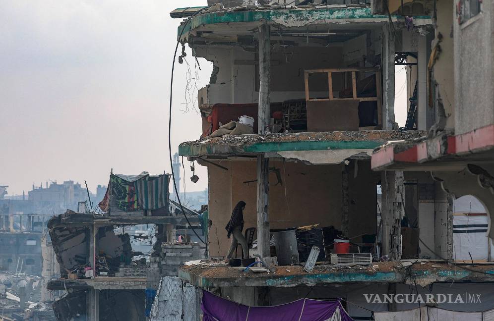 $!Una mujer palestina camina por la casa destruida de su familia en el barrio de Sheikh Radwan de la ciudad de Gaza.
