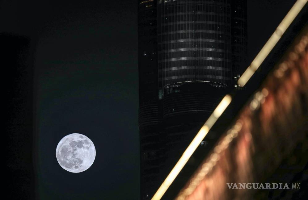 $!La Súper Luna llamada ‘Superluna de fresa’ se eleva en el cielo detrás del edificio más alto del mundo de Burj Khalifa, en Dubai, Emiratos Árabes Unidos.