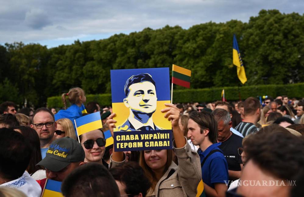 $!Una persona sostiene un cartel con el retrato del presidente ucraniano y el eslogan “Gloria a Ucrania, gloria a los héroes” en Vilnius, Lituania.