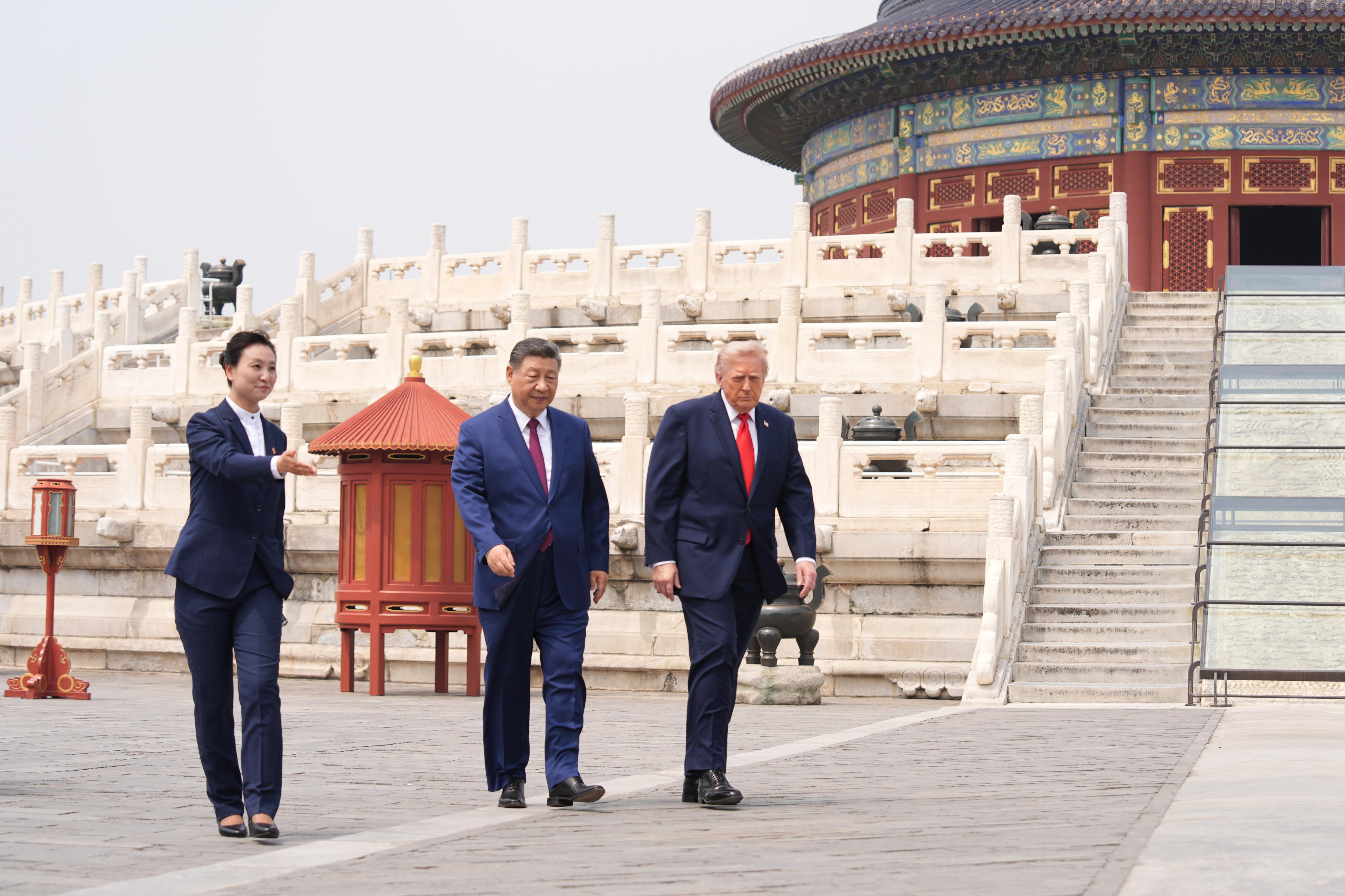 El presidente Donald Trump, a la derecha, camina junto al presidente chino Xi Jinping, en el centro, en el Templo del Cielo en Pekín.