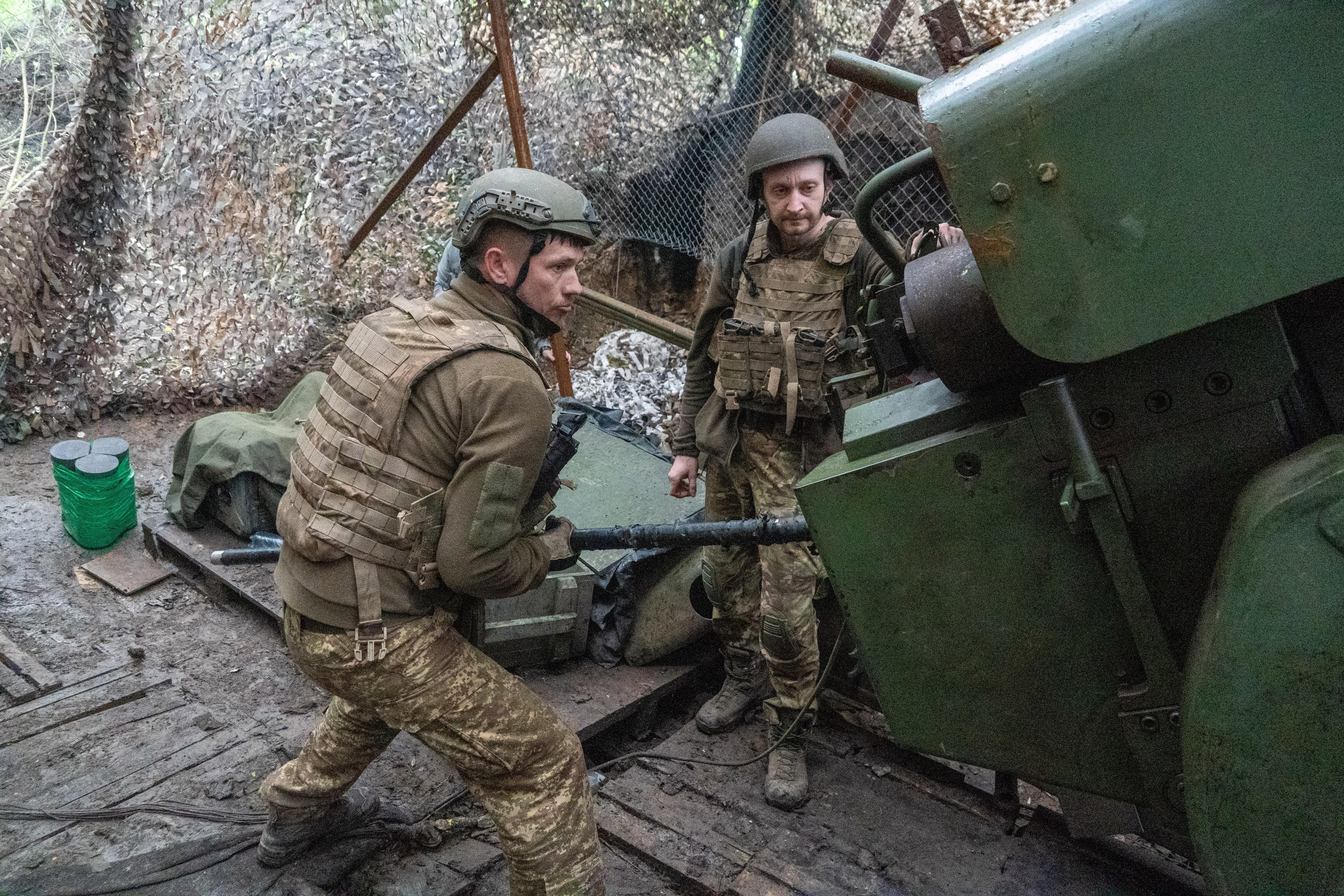 Soldados de la brigada Khartia de Ucrania disparan un cañón contra posiciones del ejército ruso cerca de Járkov, Ucrania.