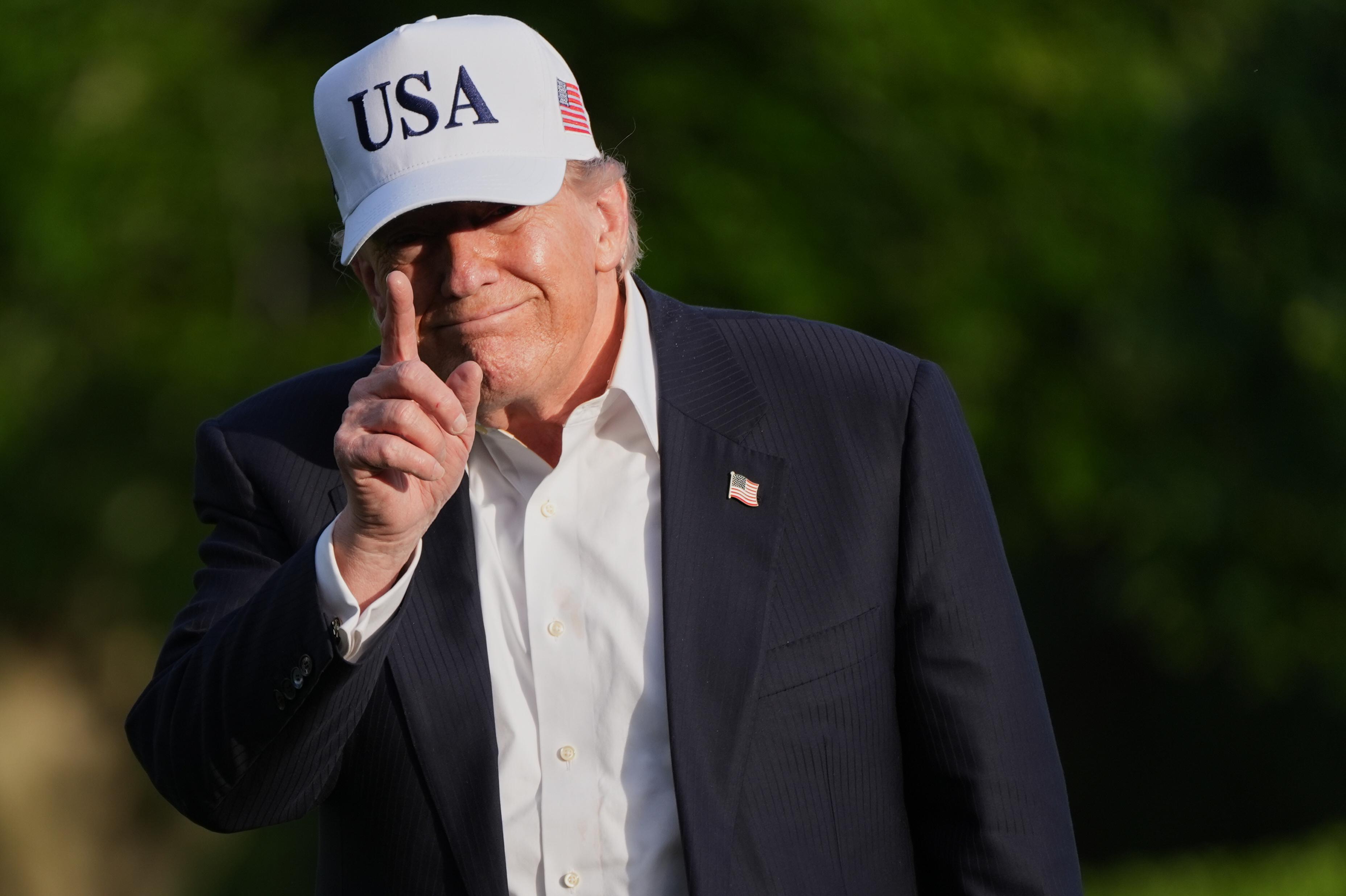 El presidente Donald Trump saluda a los periodistas mientras camina por el jardín sur de la Casa Blanca en Washington, a su regreso de Pekín, donde se reunió con el presidente chino Xi Jinping.