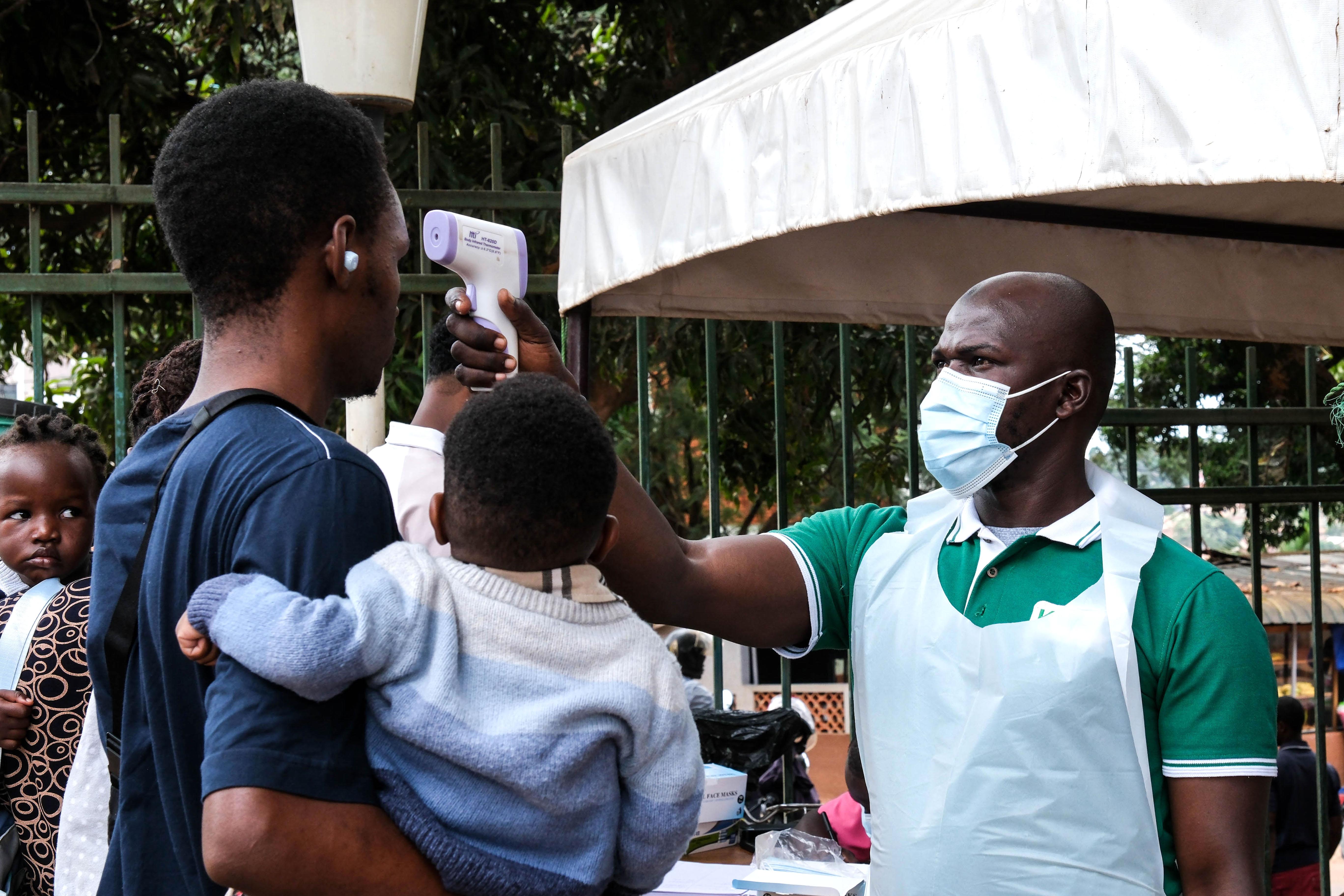 Un funcionario de salud utiliza un termómetro para examinar a las personas frente al Hospital Musulmán de Kibuli en Kampala, Uganda, el sábado 16 de mayo de 2026.