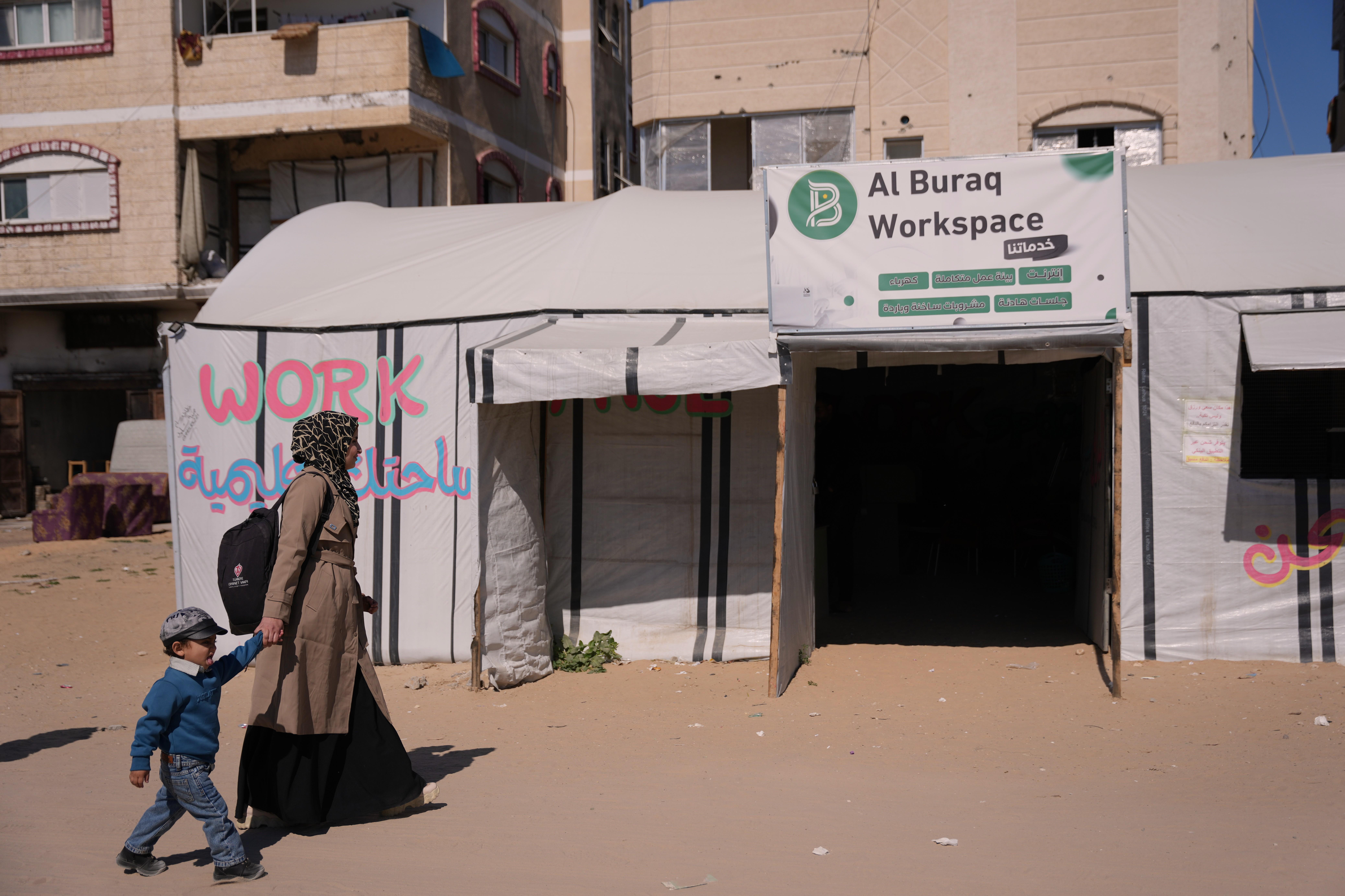 La diseñadora gráfica palestina Reem Alkhateeb y su hijo Ahmed llegan a una tienda convertida en un espacio de coworking en Jan Younis, Franja de Gaza.