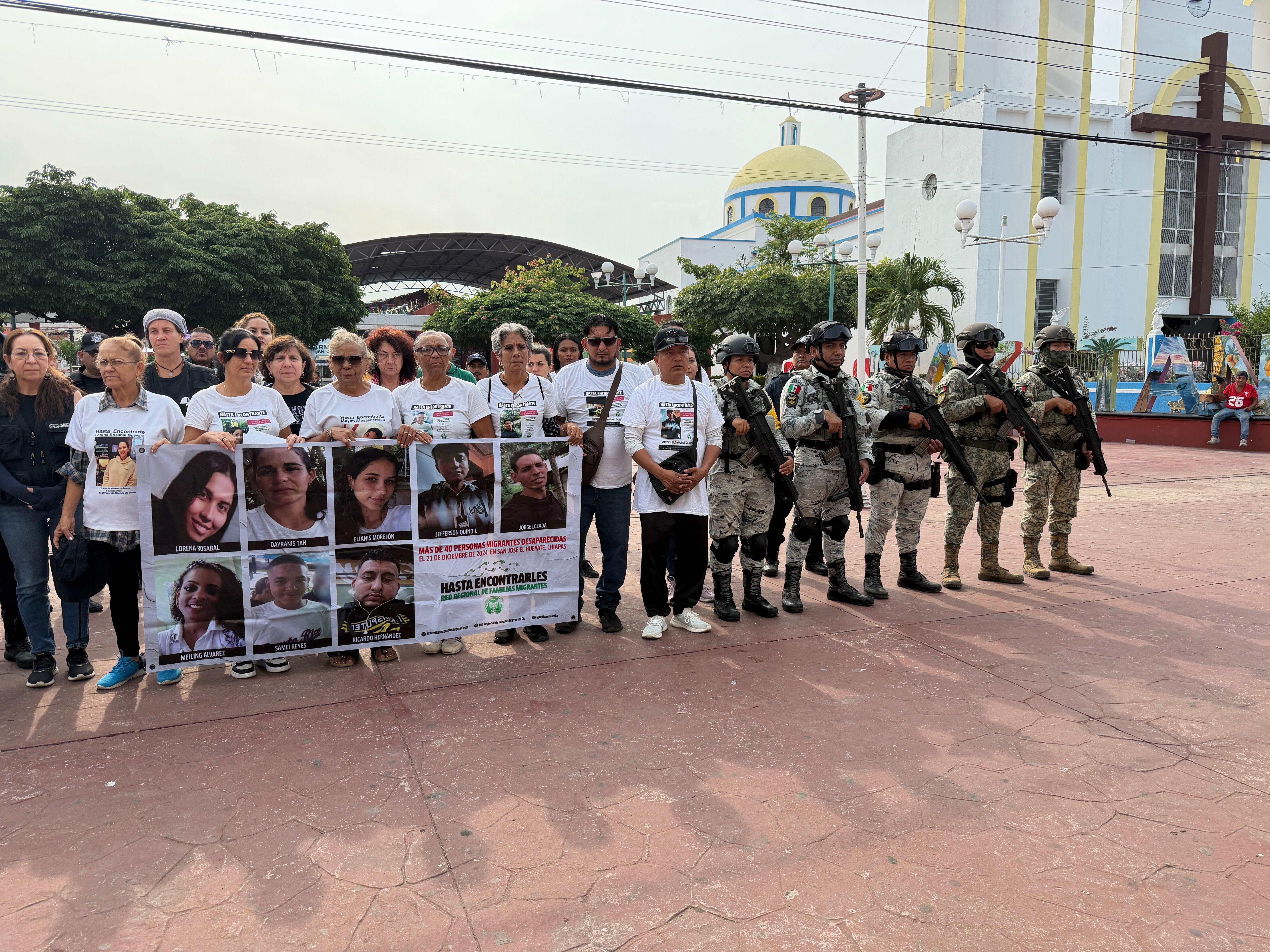 Personas que buscan a migrantes desaparecidos posan con fotos de sus seres queridos desaparecidos en Mazatán, estado de Chiapas, México.